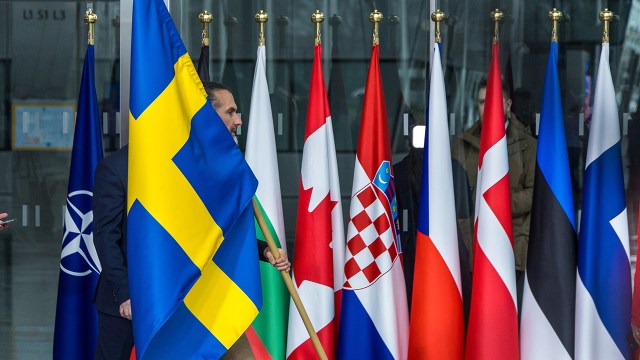 A staff member carries a Swedish flag on March 11, 2024, at NATO's headquarters in Brussels, ahead of a ceremony marking Sweden's joining of the military alliance. (Omar Havana/Getty Images)